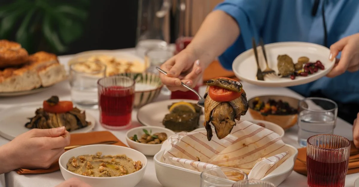 Une scène de dîner conviviale où des amis partagent des plats méditerranéens et des boissons.