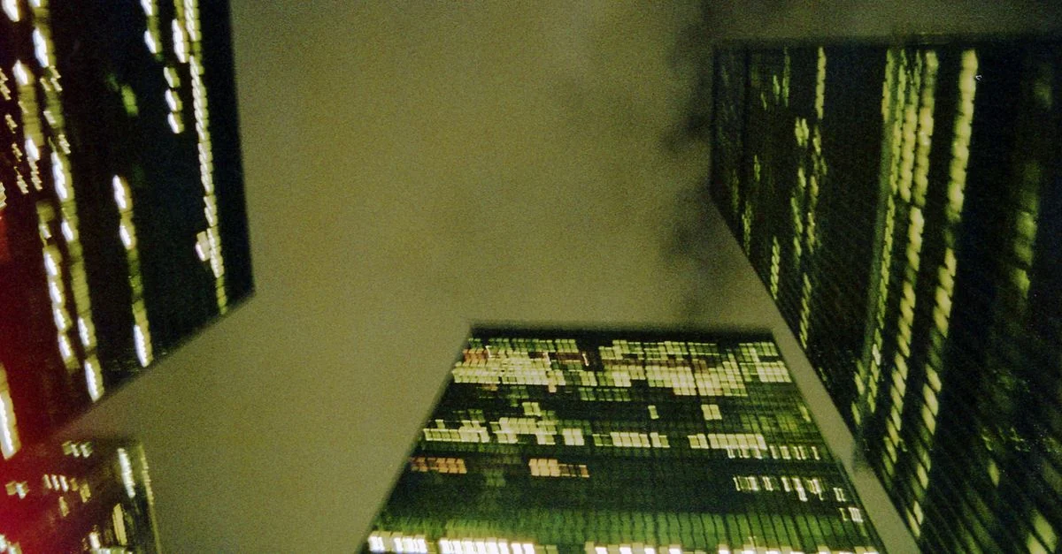 Prise de vue dramatique en basse angle des gratte-ciels de Toronto sous un ciel nuageux nocturne, mettant en valeur les lumières de la ville.